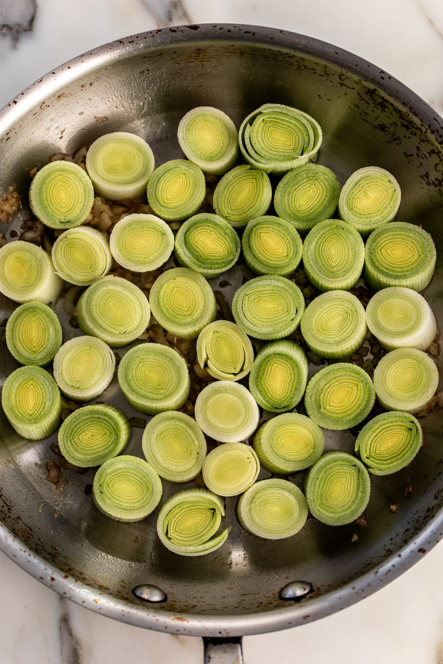 sautéed round of leeks in pan.