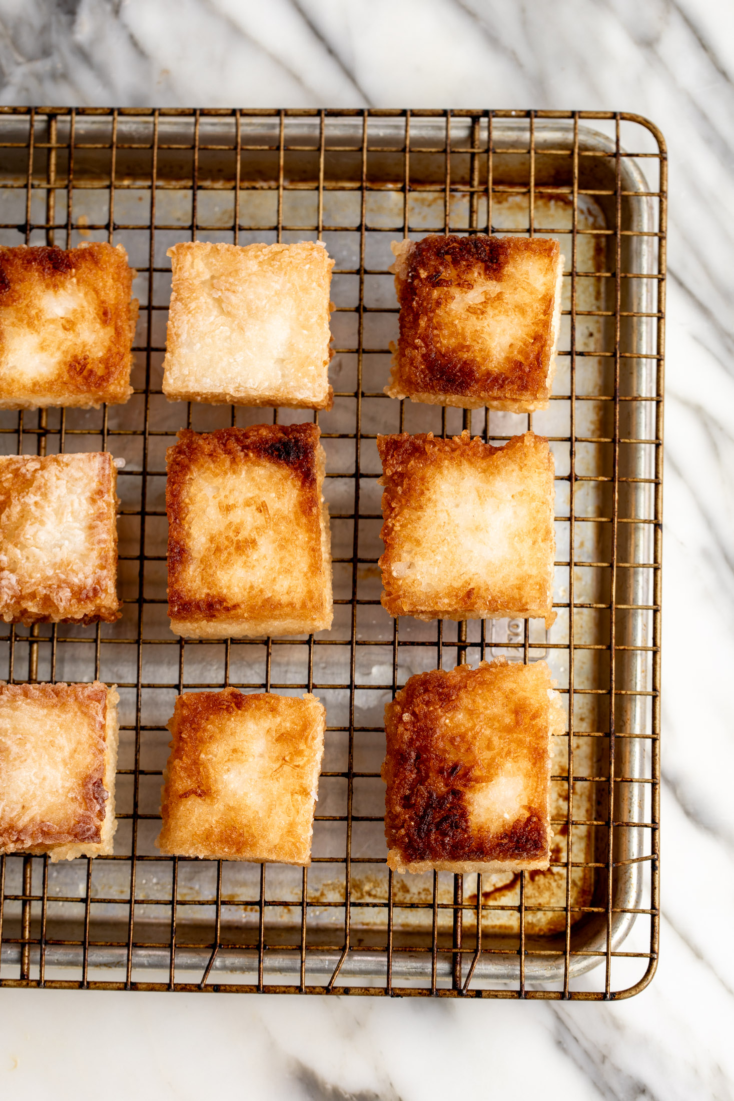 fried golden squares of crispy rice on cooling rack.