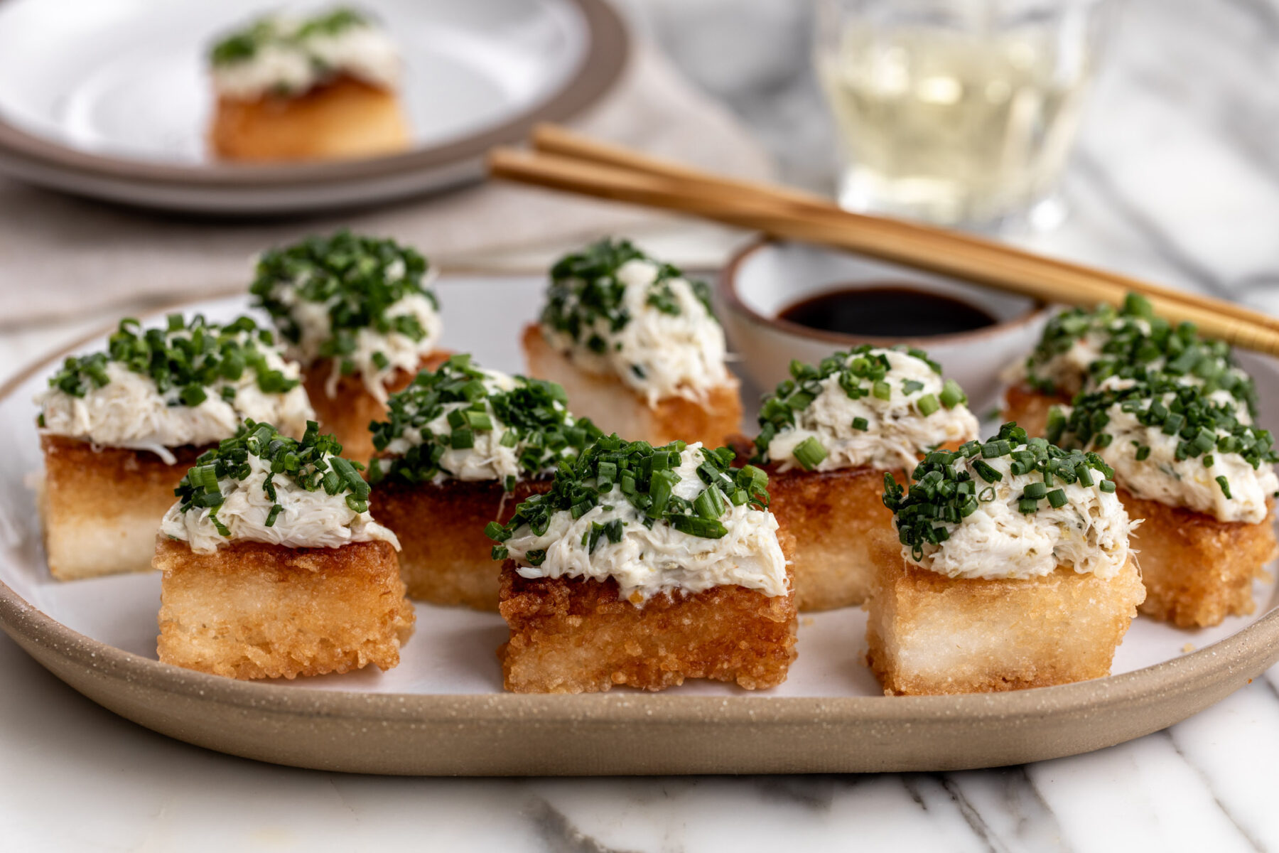 spicy crab crispy rice with yuzu kosho on platter with soy sauce for dipping.