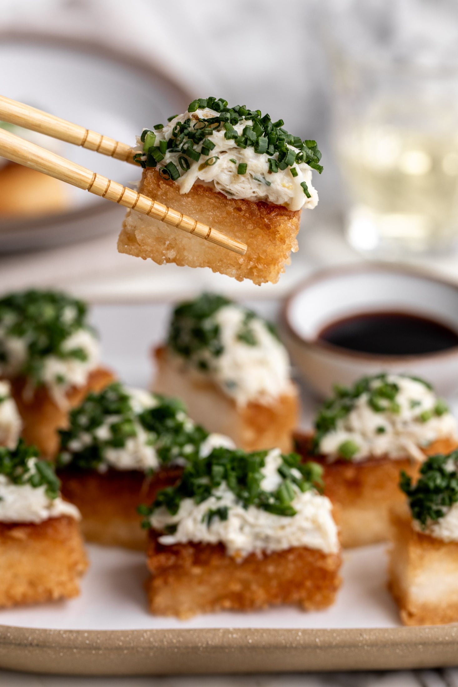 spicy crab crispy rice with yuzu kosho on chopsticks.