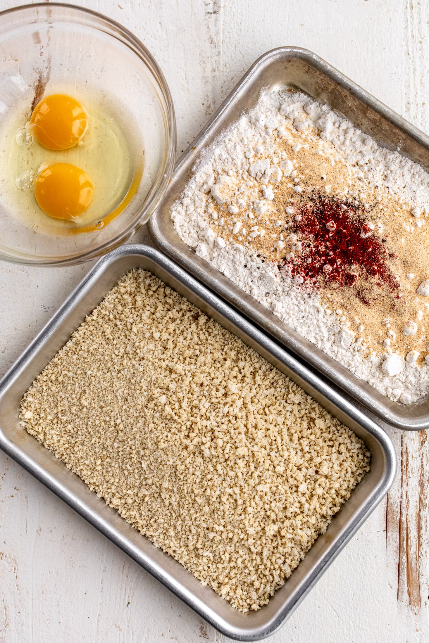 dredge for fish sandwich with flour, eggs and panko breadcrumbs in trays.