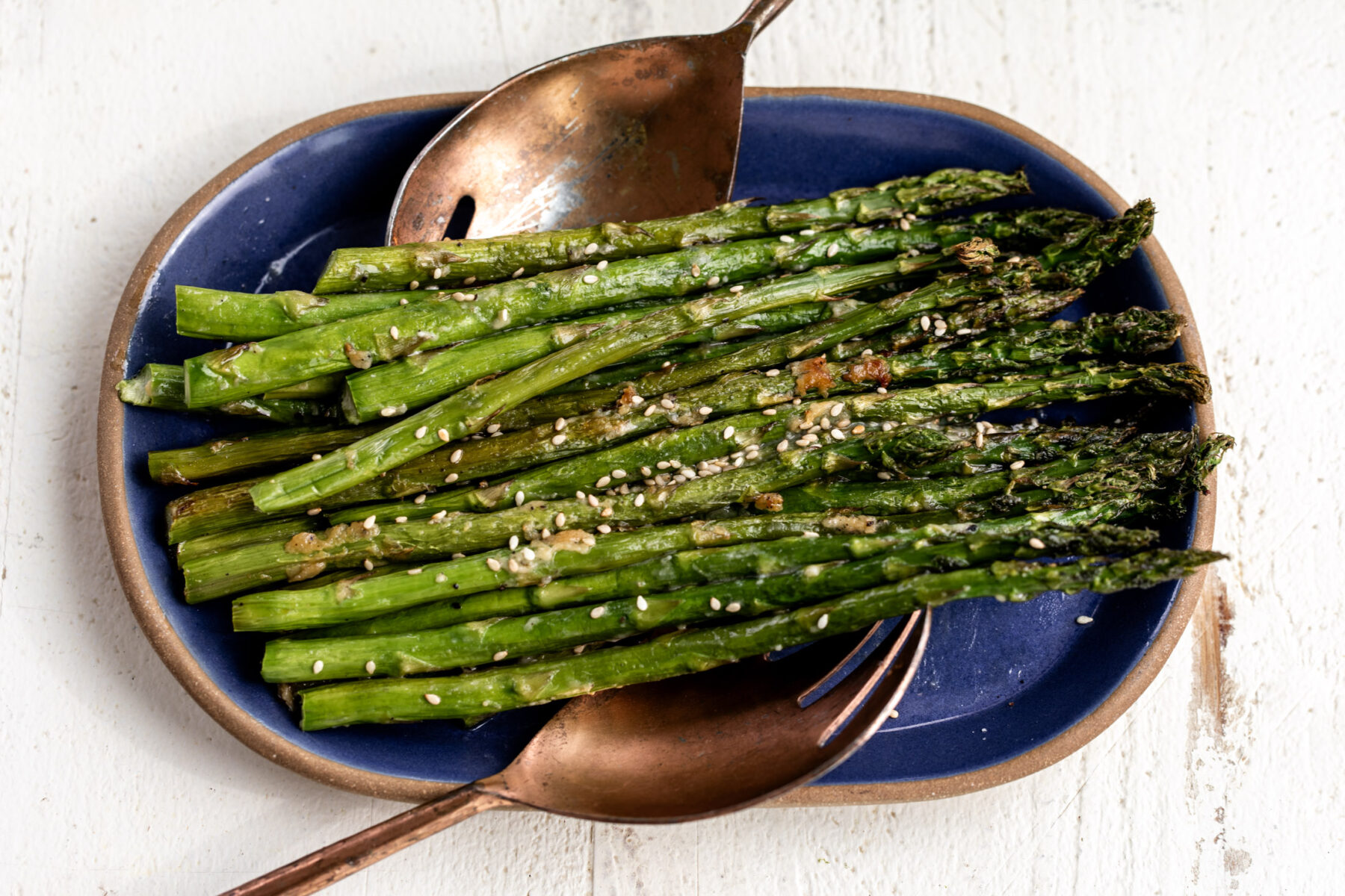 roasted miso butter asparagus on blue platter.
