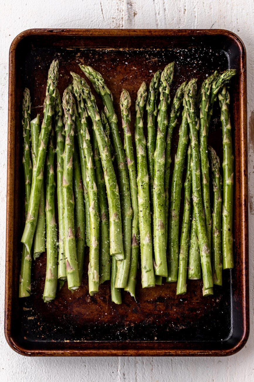 asparagus tossed in oil on baking sheet.