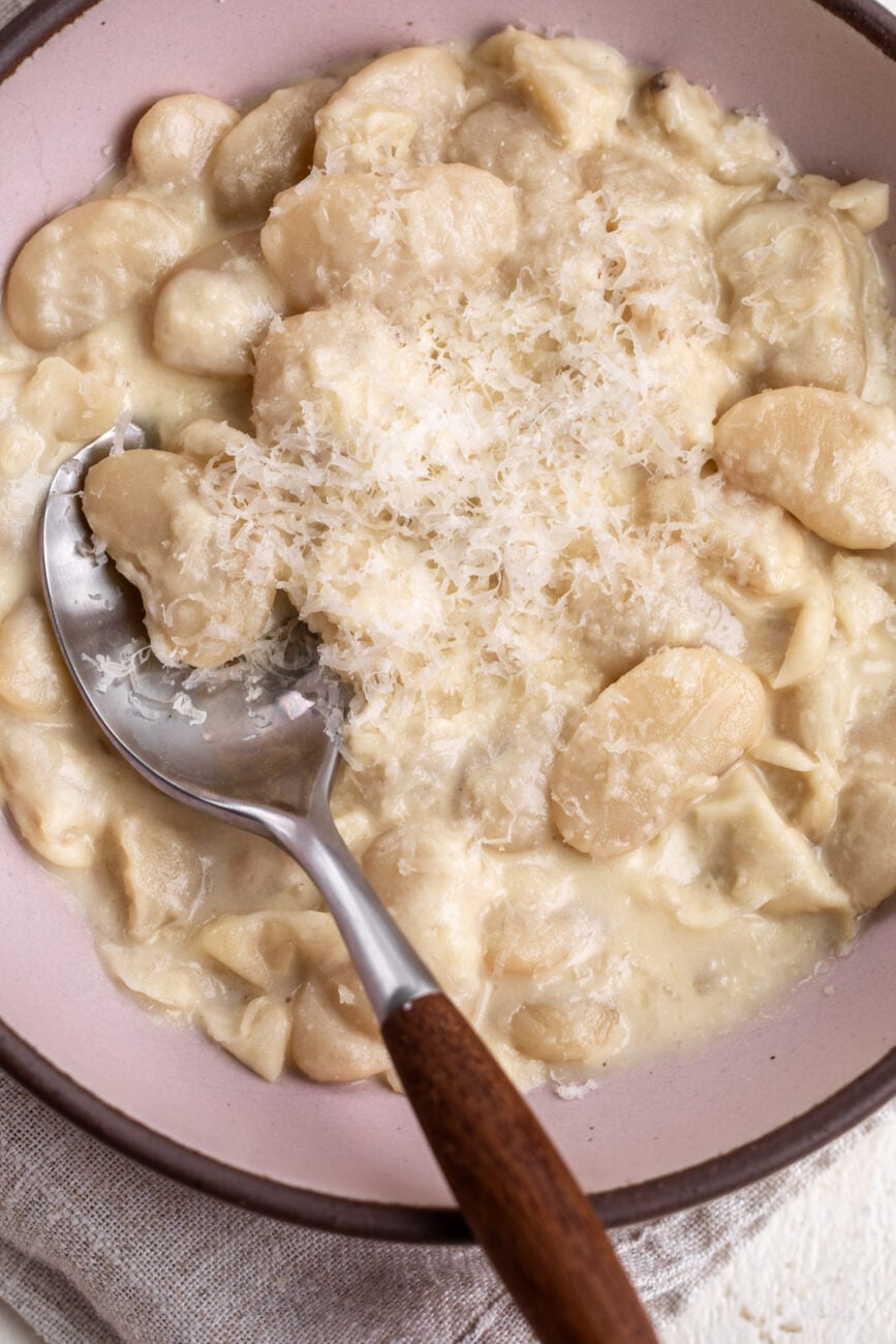 10-minute Alfredo butter beans garnished with parmesan cheese with a side of bread.