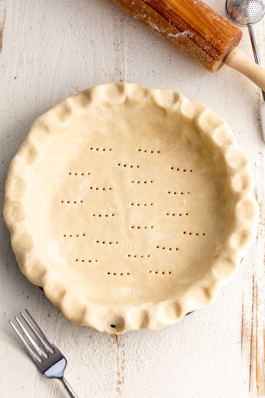 pie crust with docking marks prepped for the oven.