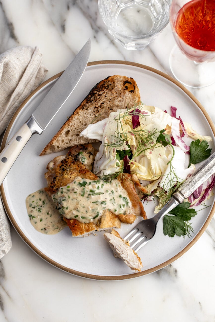 brick chicken with creamy herb pan sauce, salad and bread.