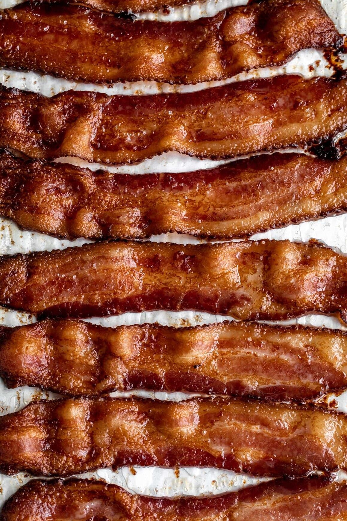 crispy baked bacon on lined baking sheet.