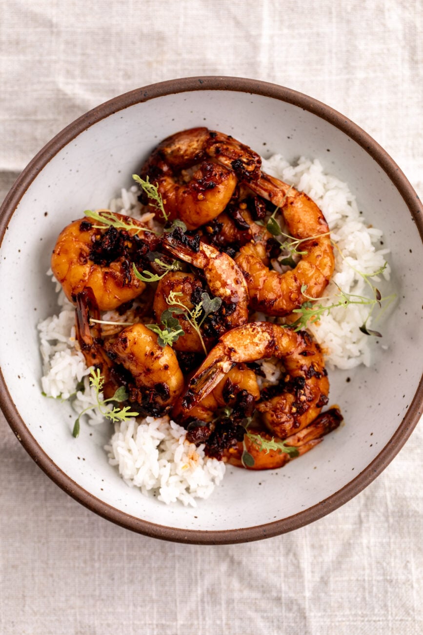 shrimp served over white rice with chili crisp sauce.