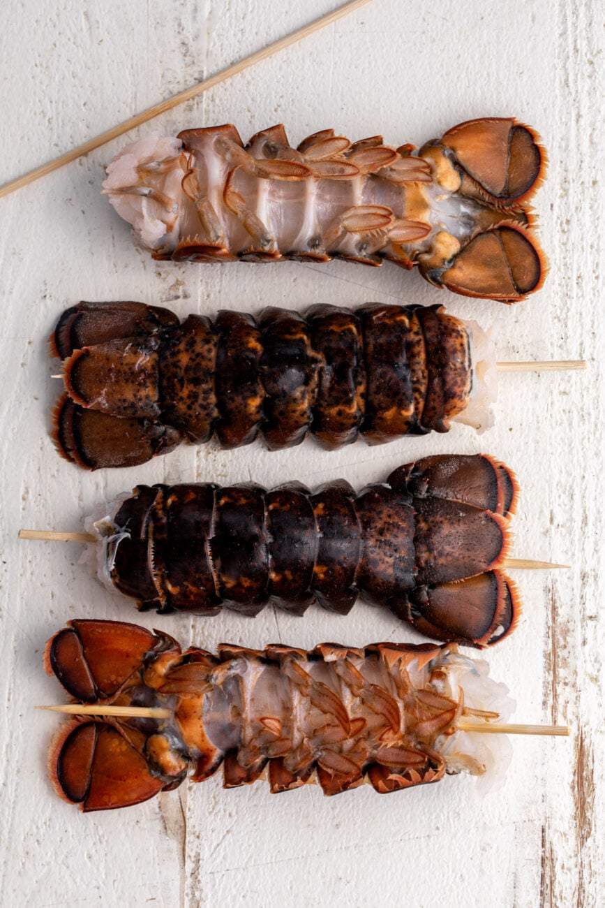 lobster tails with bamboo skewers through tail.
