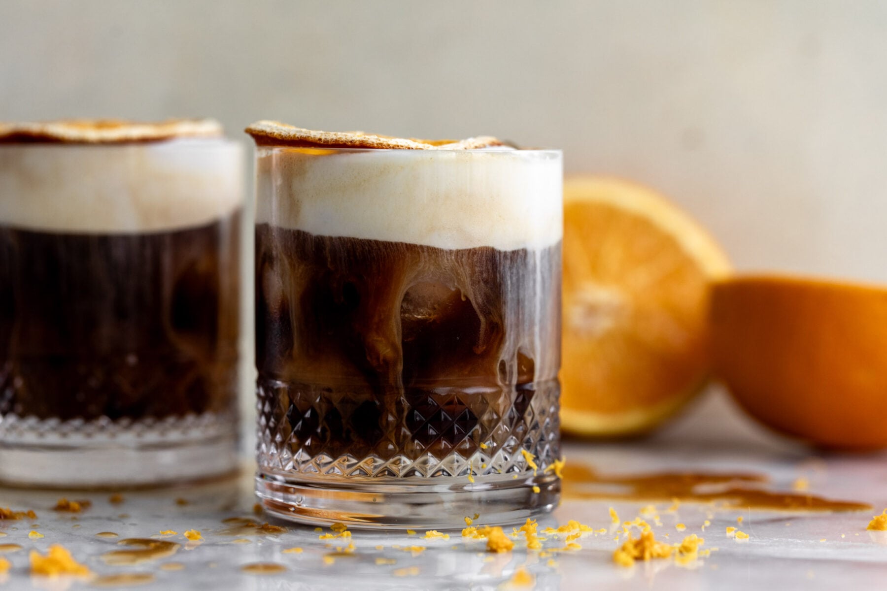 mont blanc iced coffee with orange cold foam and dried orange slice garnish.