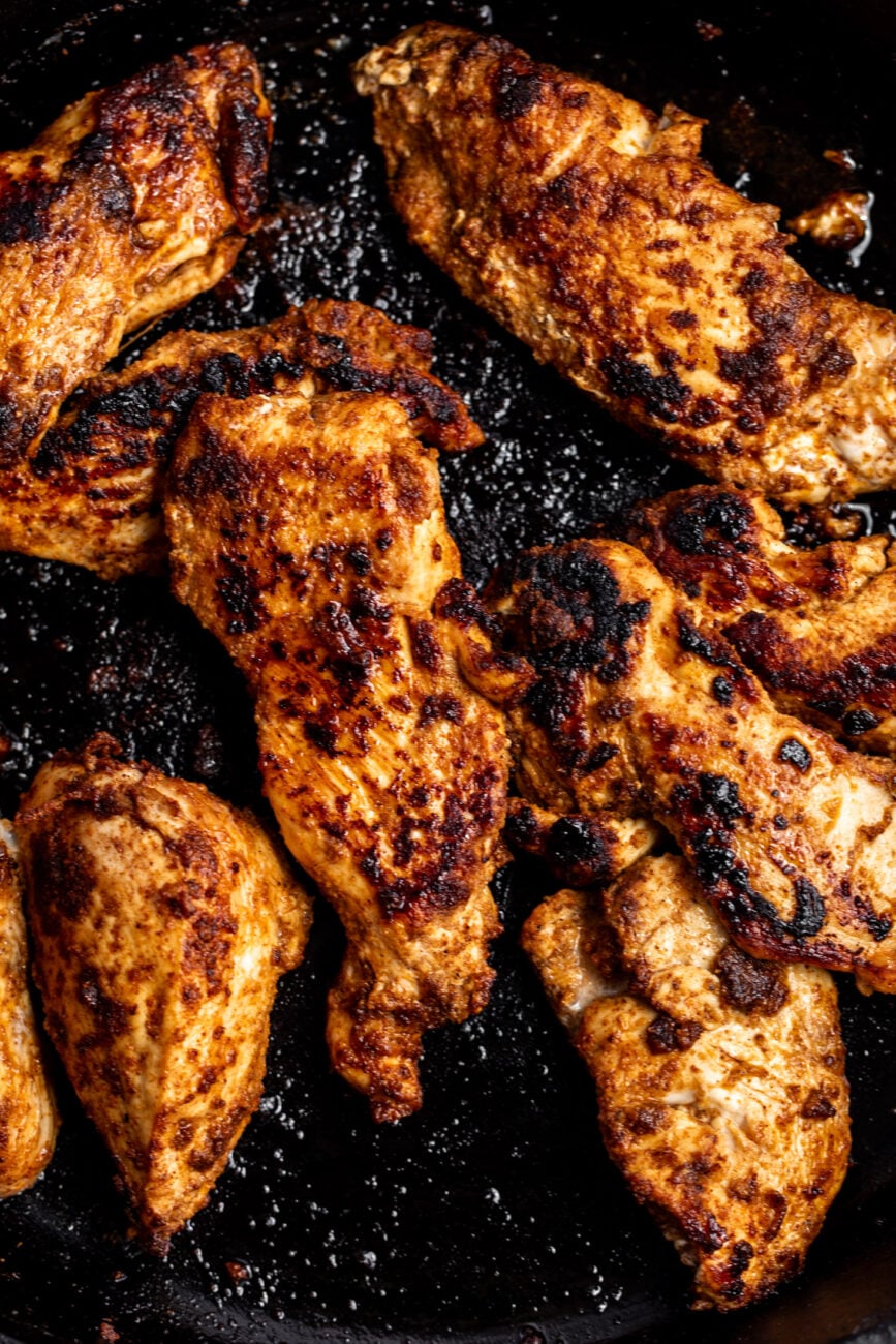 cooked seasoned chicken breasts in pan.