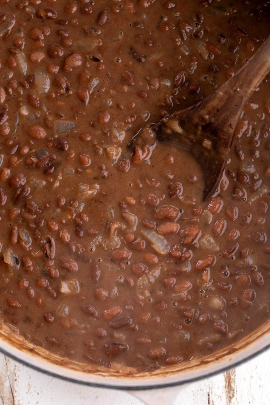 simmered beans in pot with onions.