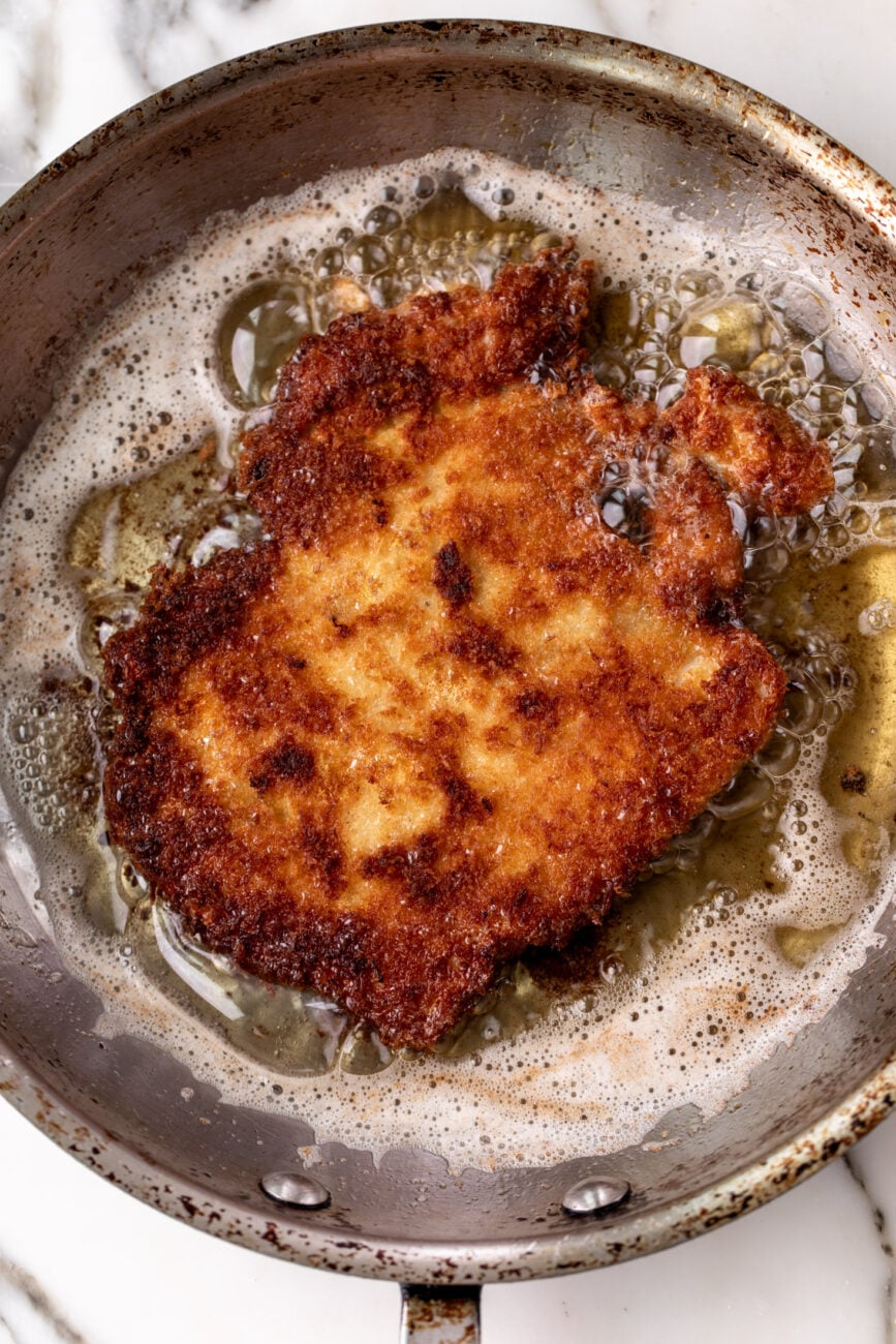 breaded crispy chicken cutlet frying in oil.
