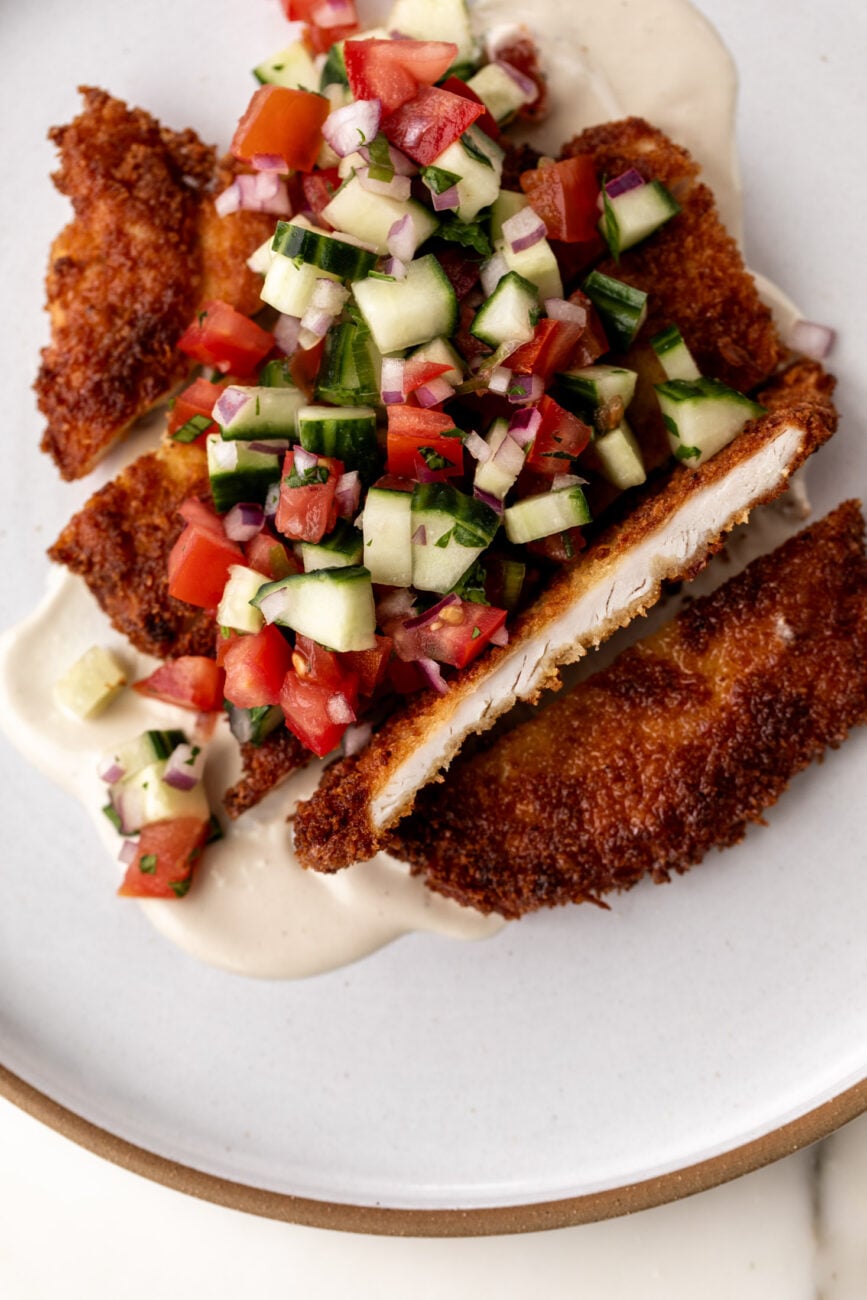 chicken cutlet with tahini and tomato cucumber salad.