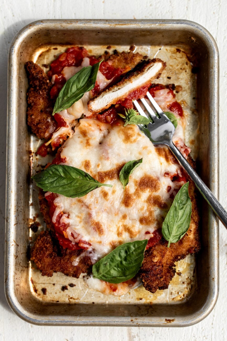 crispy chicken cutlets with tomato sauce, mozzarella and basil leaves.