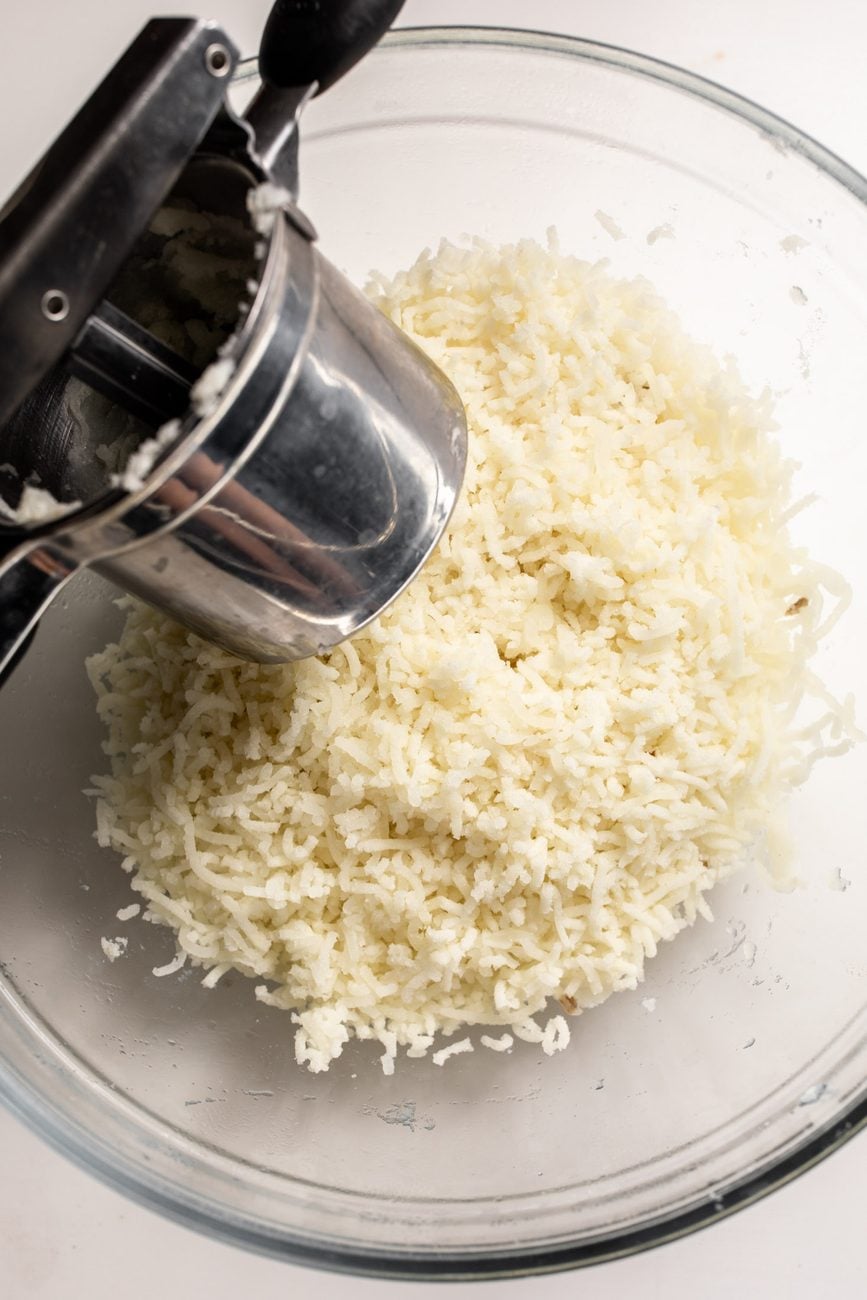 potatoes in potato ricer. 