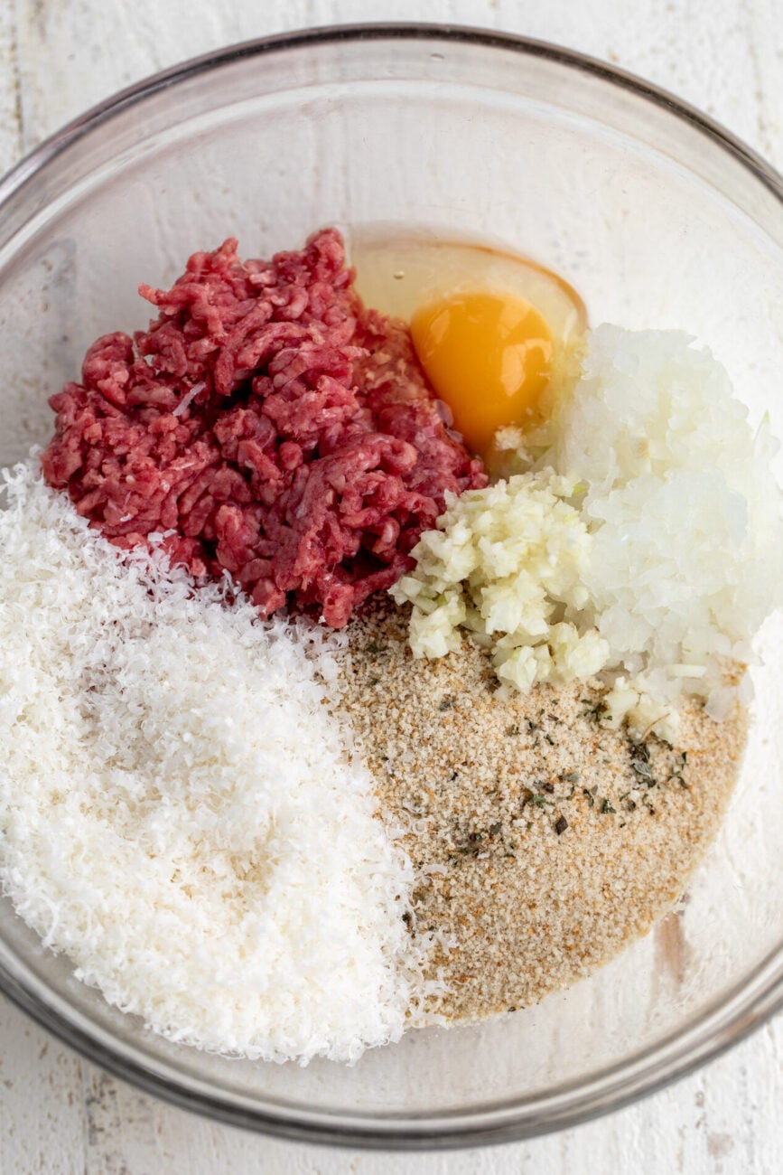 ingredients for mini meatballs in mixing bowl with breadcrumbs.